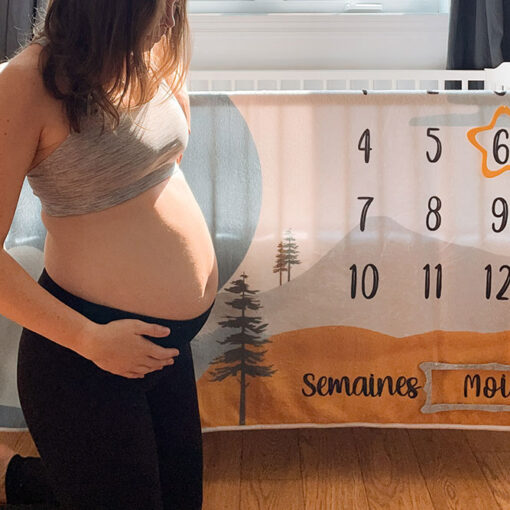 Femme enceinte souligne 6 mois de grossesse avec doudou bleu et orange