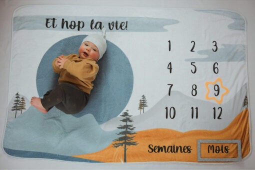 photo mensuelle 9 mois d'un petit garçon sur couverture à motif de montagnes