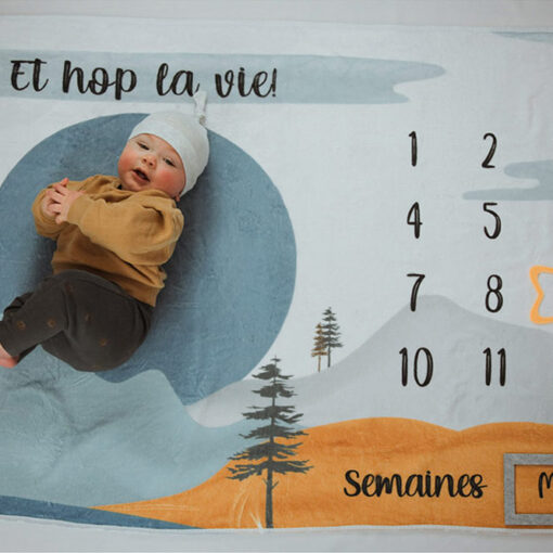 photo mensuelle 9 mois d'un petit garçon sur couverture à motif de montagnes