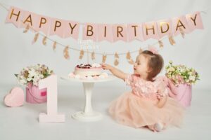 Petite fille qui joue avec les cadeaux de son premier anniversaire